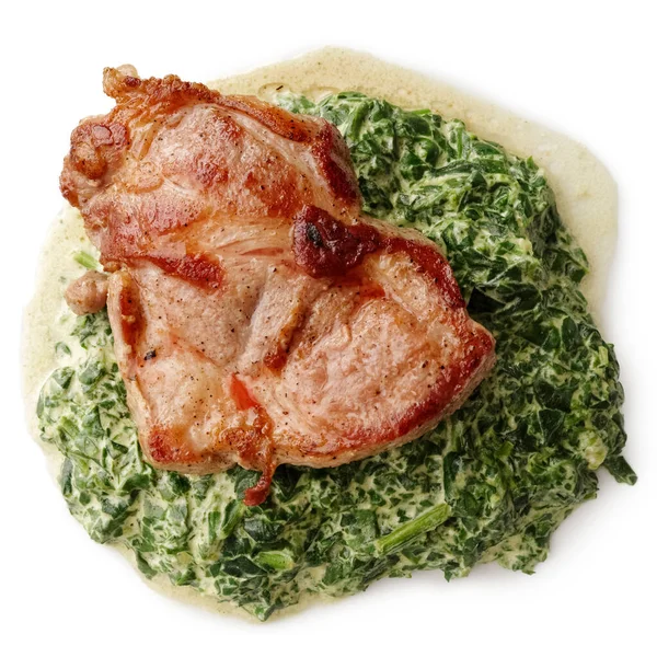 Gegrillter Schweinenacken auf Spinatcremesauce von oben. — Stockfoto