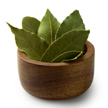 Kurumuş körfez yaprakları, koyu bir ahşap kasenin içinde..