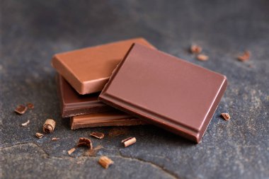 Gri levhada izole edilmiş dört adet siyah ve sütlü çikolata.. 