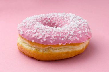 Pembe üzerine kristal şeker serpiştirilmiş donut.