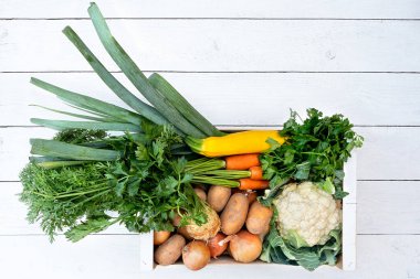 Çiftçi pazarından taze sebzelerle dolu ahşap kutu beyaz acılarla dolu.