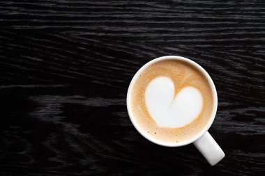 Beyaz seramik bardakta kalp şeklinde köpüklü kapuçino izole et.