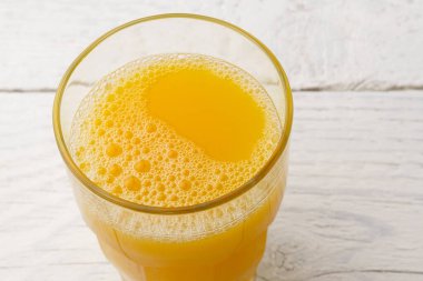 Beyaz boyaya izole edilmiş taze sıkılmış bir bardak portakal suyu.
