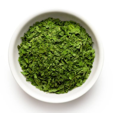 Beyaz seramik kasede kurutulmuş maydanoz.