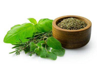 Koyu bir ahşap kasede taze B 'nin yanında kurutulmuş Provence otları.