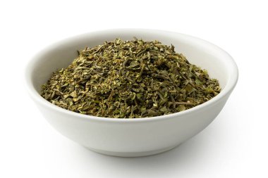 Beyaz bir seramik kasede izole edilmiş kurutulmuş provence otları.