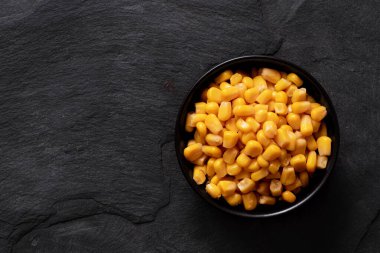 Siyah seramik kasede izole edilmiş konserve mısır.