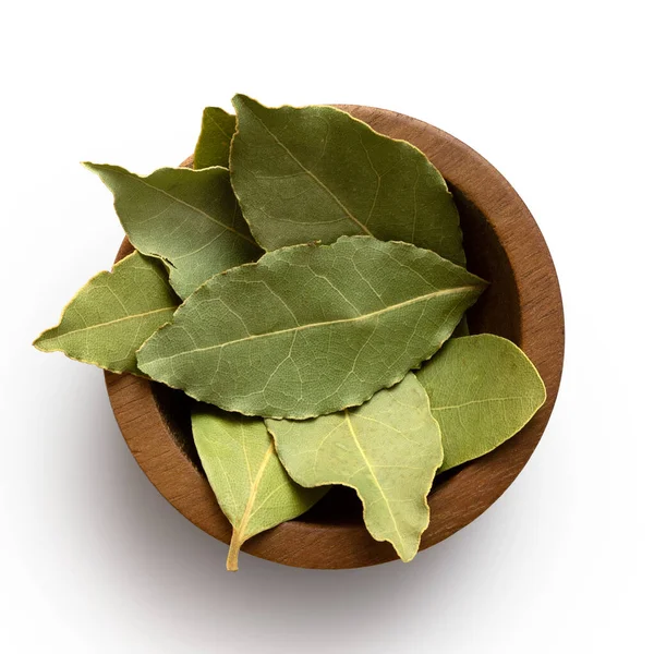 Dried bay leaves in a dark wood bowl isolated on white from abov — Stock Photo, Image