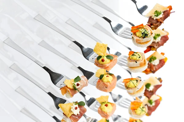 Mixed canapes on metal forks. White background. — Stock Photo, Image