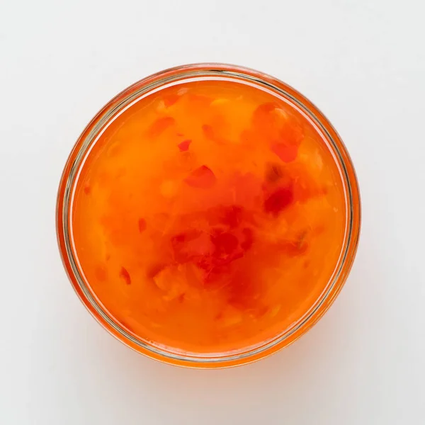 白色陶瓷碗中的甜辣椒酱，用白勺隔开 — 图库照片