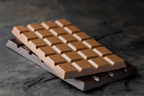 Een plak melkchocolade bovenop een plak pure chocolade isol — Stockfoto