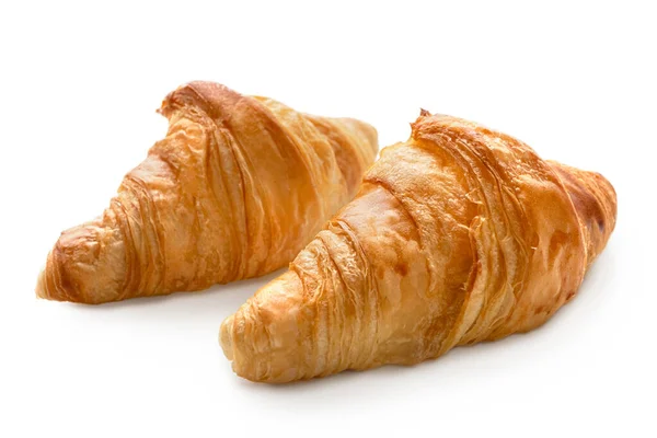 Kaksi paistettua tavallista croissantia, jotka on eristetty valkoiselle . — kuvapankkivalokuva
