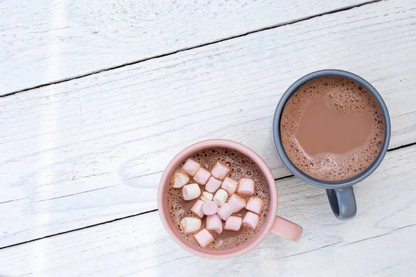 Chocolate quente em duas canecas, uma com pequenos marshmallows, isolado — Fotografia de Stock