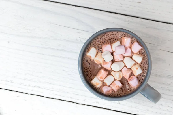 Hot chocolate with small marshmallows in a blue-grey ceramic mug