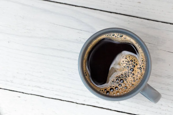 Fekete kávé egy kék-szürke kerámia bögrében, fehér festéken izolálva. — Stock Fotó