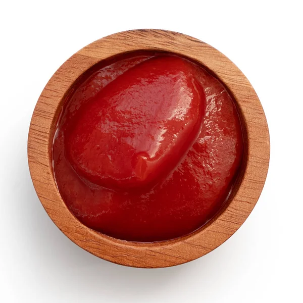 Ketchup de tomate en un pequeño plato de madera aislado en blanco. Vista superior . — Foto de Stock