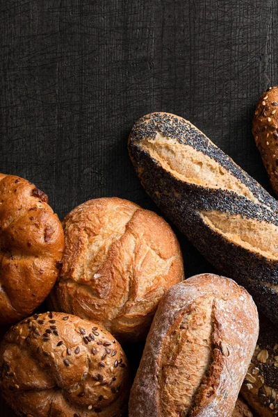 Baguettes mixtos y panecillos en madera gris oscuro. Vista superior. Spa — Foto de Stock