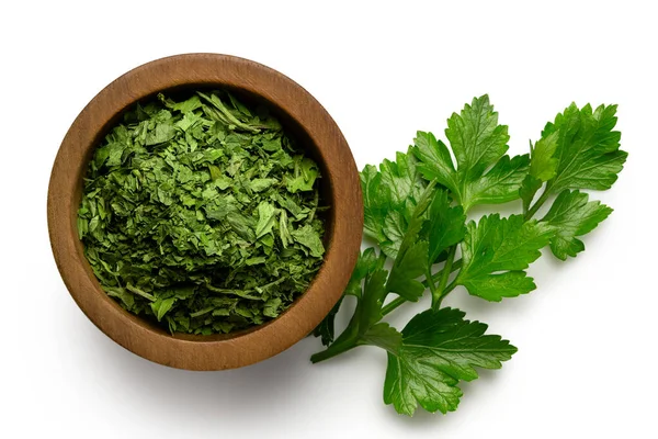 Dried chopped parsley in dark wood bowl next to fresh parsley le — Stock Photo, Image
