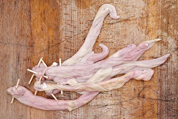 Embutidos de cerdo con pinchos sobre tabla de madera vieja desde arriba — Foto de Stock