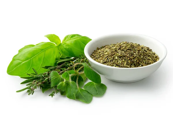 Dried chopped provence herbs in a white ceramic bowl next to fre — Stock Photo, Image