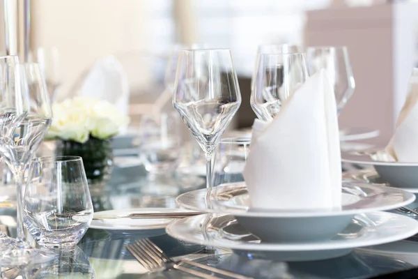 Detalle de la configuración moderna del banquete en la mesa de cristal. Fondo borroso —  Fotos de Stock