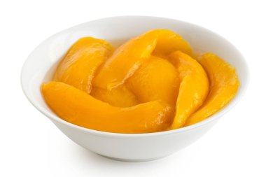 Konserve mango şerbet dilimleri beyaz seramik bir kasede izole edilmiş..