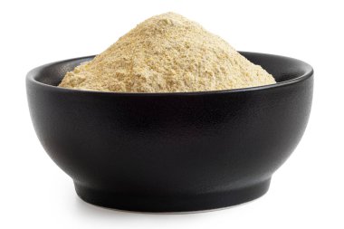 Beyaz üzerine izole edilmiş siyah seramik kasede kurutulmuş mercimek unu. Düşük açı.