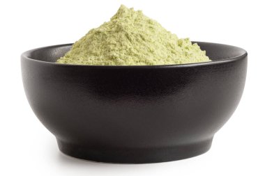 Beyaz üzerine izole edilmiş siyah seramik kasede kurutulmuş yeşil bezelye unu. Düşük açı.