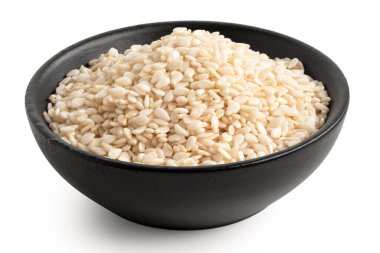 Siyah bir seramik kasede soyulmuş susam tohumları beyaza izole edilmiş. Yüksek açı.