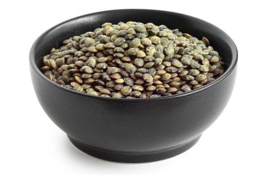 Dry french green puy lentils in black ceramic bowl isolated on white. High angle. clipart