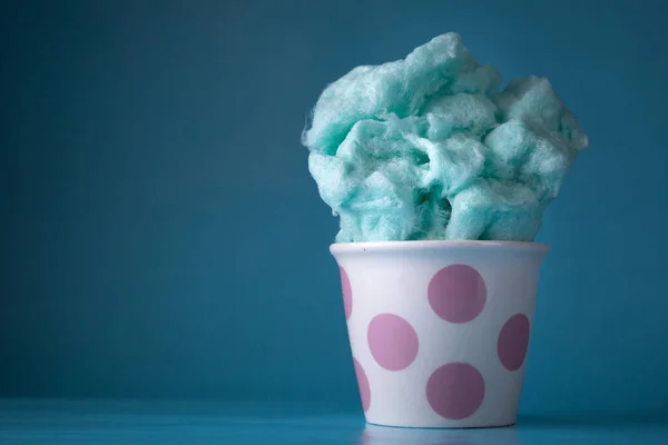 Blue cotton candy in bowl on blue background