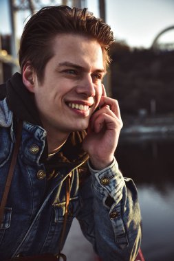 Sevimli gülümseyen adam gelini telefon ayakta konuşurken. Portre kadar kapatın