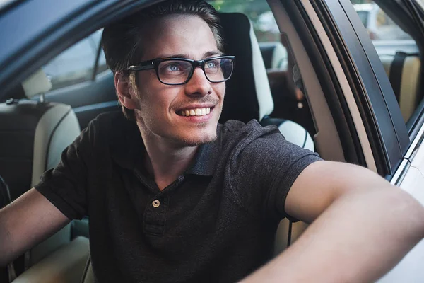 İyi yolculuklar. Arabada oturan yakışıklı bir genç resmi..