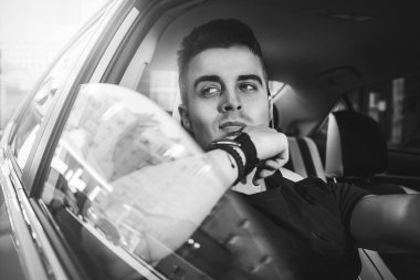 İyi yolculuklar. Arabada oturan yakışıklı bir genç resmi..