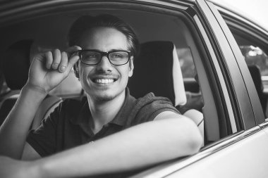 İyi yolculuklar. Arabada oturan yakışıklı bir genç resmi..