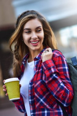 Kentsel tarzı harika kız yürümek kahve ile şehirde.