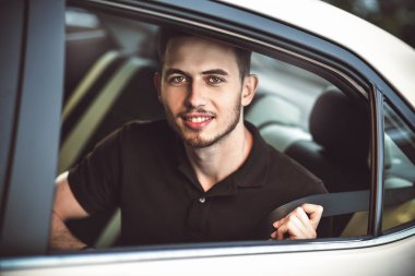 Genç, yakışıklı adam arabanın arka koltuğunda oturan bir emniyet kemeri bağlamamak..