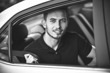 Genç, yakışıklı adam arabanın arka koltuğunda oturan bir emniyet kemeri bağlamamak..