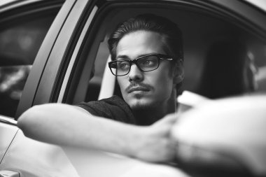 İyi yolculuklar. Arabada oturan yakışıklı bir genç resmi..