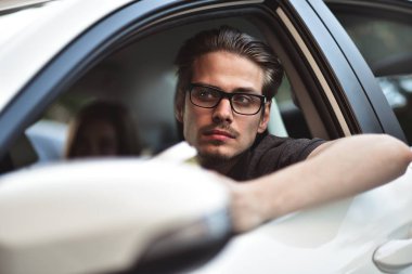 İyi yolculuklar. Arabada oturan yakışıklı bir genç resmi..