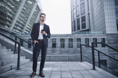 Yakışıklı başarılı iş adamı açık havada şehirde sokakta yürüme zarif takım elbise.