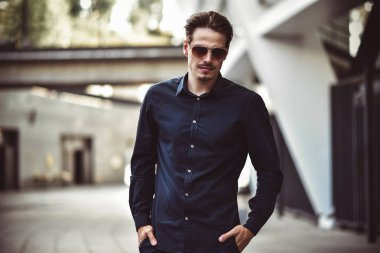 Genç şık ve kendinden emin mutlu yakışıklı işadamı modeli güneş gözlüğü sokakta gömlek yaşam tarzı
