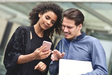 İş adamı ve şehir açık mutlu hissediyor içinde arka bina birlikte smartphone vasıl arayan kadın.