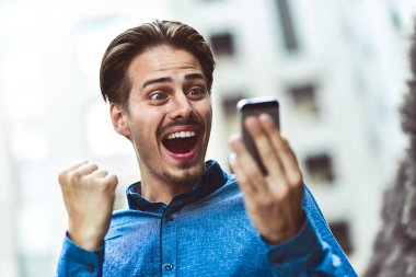 İyi haber ileti e-posta okuma onun smartphone vasıl görünen heyecanlı adam.