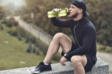 Kas sakallı sporcu içmek bir su iyi egzersiz oturum sonrası Şehir Parkı.
