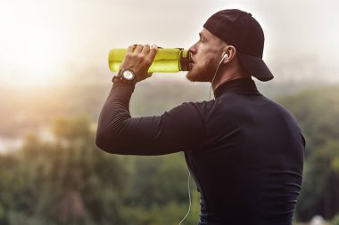 Yakın çekim Shot sakallı sportif adam istirahat etmek ve egzersiz oturum sonra su.