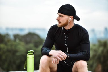 Akıllı nöbet yanık kalori iyi egzersiz oturum sonrası Şehir Parkı üzerinde kontrol kas sakallı atlet.