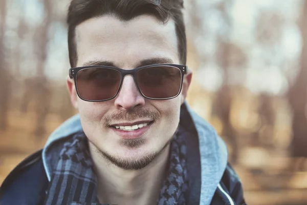 Retrato de moda de hombre europeo en gafas de sol caminando por el parque — Foto de Stock