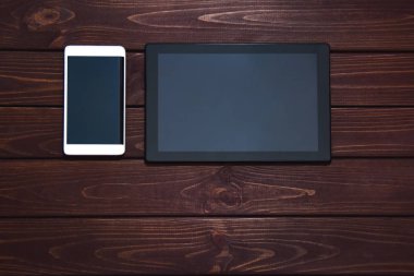 ahşap masa üzerinde modern akıllı telefon ve tablet