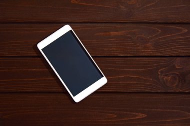 Ahşap masa arka planda boş ekranlı cep telefonu. Ahşap eski tahta vintage doku arka plan akıllı telefon. üst görünüm